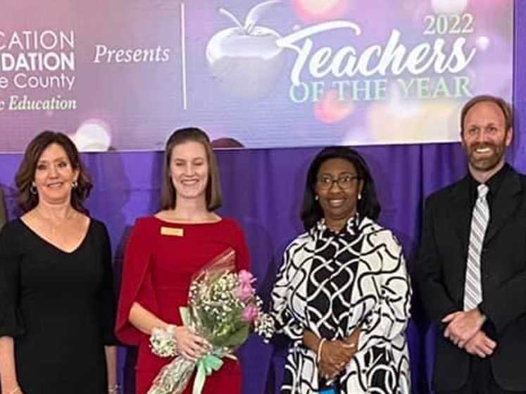 Lake County School Board members Mollie Cunningham and Marc Dodd stand on stage with 2021-2022 Lake County Teacher of the Year finalist Rikki Parisoe at the Teachers of the Year ceremony on January 28th, 2021.